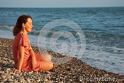 Young woman sits ashore of sea Stock Photo