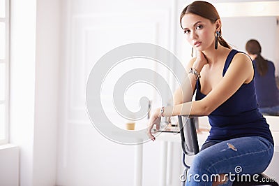 Young woman sitting on a chair isolated over white background Stock Photo