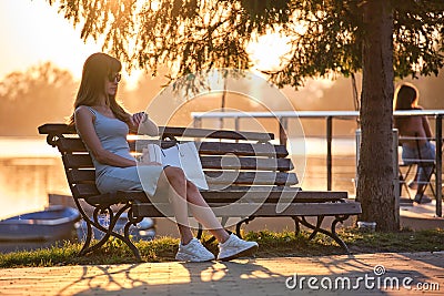 Young woman sitting on city street alone waiting for someone to arrive. Being late on date meeting concept Stock Photo