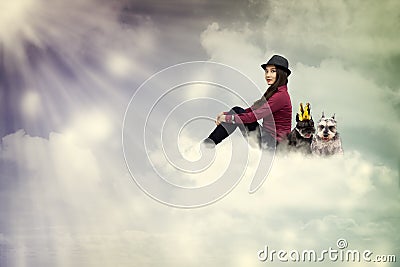 Young woman sitting on the cloud with dogs Stock Photo