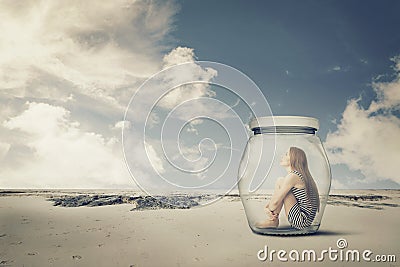 Young woman sitting in a jar in the desert. Loneliness outlier concept Stock Photo