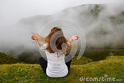 Young woman sitting in lotus position at mountains. Editorial Stock Photo