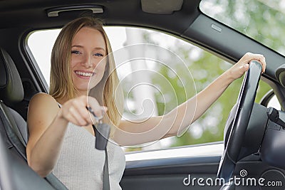 young woman sitting in new car showing car keys Stock Photo
