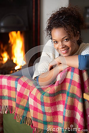 Young woman sitting by open fire Stock Photo