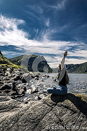 Young woman sitting on the rocks, Norway Stock Photo