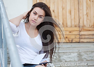 Young woman sitting on the stairs Stock Photo