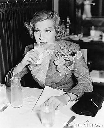 Young woman sitting at a table in a restaurant drinking milk Stock Photo