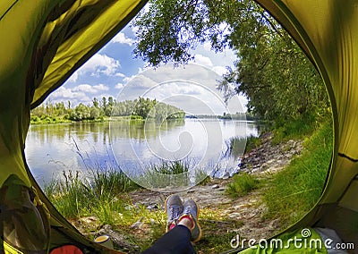 Young woman sitting in the tent while looking on the Desna river Stock Photo