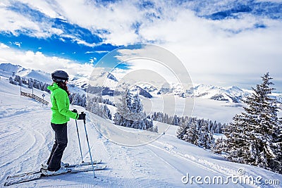 Young woman skiing in Kitzbuehel ski resort and enjouing the beautiful weather with blue sky and Alpine mountains in Austria. Stock Photo