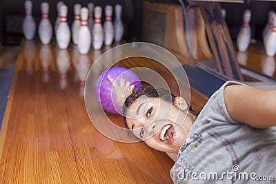 Young woman sliding down a bowling alley Stock Photo