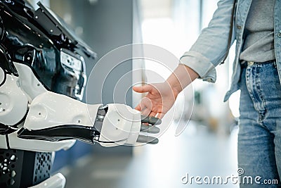 Young woman shaking a modern robot hand Stock Photo