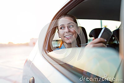 Woman with phone on the back seat of a car Stock Photo