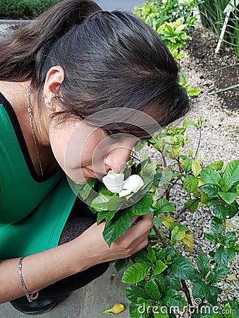 young woman smelling a flower of gardenia Stock Photo