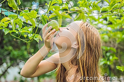 Young woman smelling the passion fruit in the garden Stock Photo