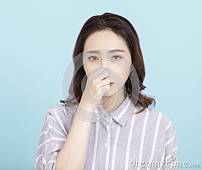 Young woman smelling something stinky and disgusting Stock Photo