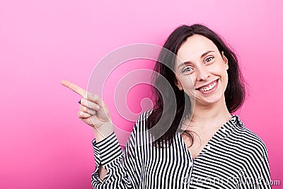 Young woman smiling and pointing to her right Stock Photo