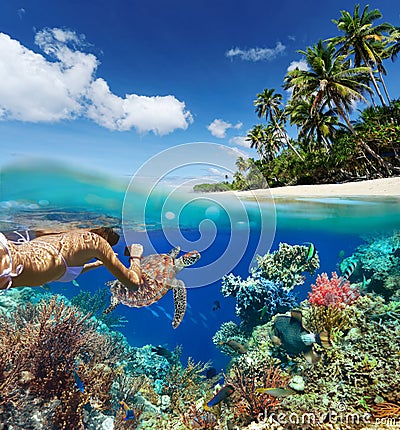 Young woman snorkeling over coral reef in tropical sea. Stock Photo