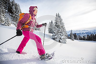 Young woman snowshoeing in high mountains Stock Photo