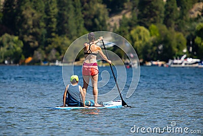 Young woman with son paddle boarding Editorial Stock Photo