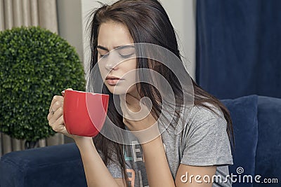 Young woman with a sore throat drinking tea Stock Photo