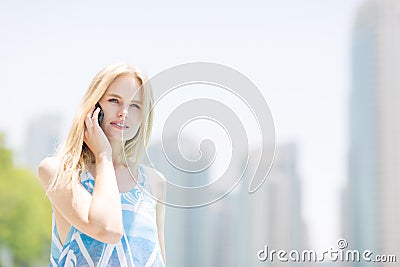 Young woman speaking on a mobile phone in the city. Stock Photo