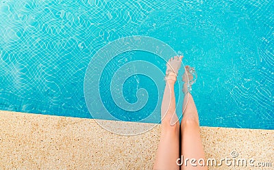 Young woman splashing feet in pool Stock Photo