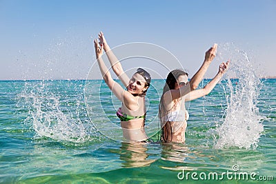 https://thumbs.dreamstime.com/x/young-woman-sprinkles-water-sea-two-beautiful-girls-bathing-suits-sunglasses-fun-squirting-hot-day-69375699.jpg