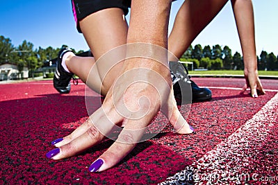 Young woman in sprinting position Stock Photo