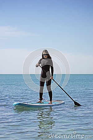 Young Woman Stand Up Paddle Boarding Stock Photo