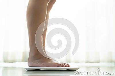 Young woman standing on digital weight scale Stock Photo