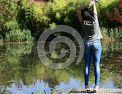 Young woman standing on the edge of a lake Editorial Stock Photo