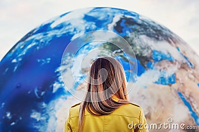 Young woman standing in front of large inflatable model of planet Earth, detail on Europe northern Africa, Middle east, view form Stock Photo