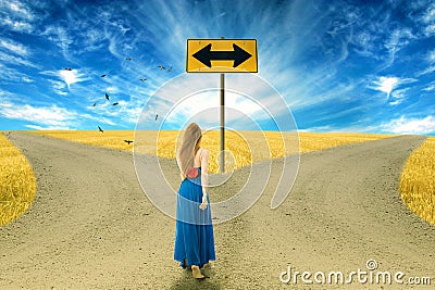 Young woman standing in front of two roads Stock Photo