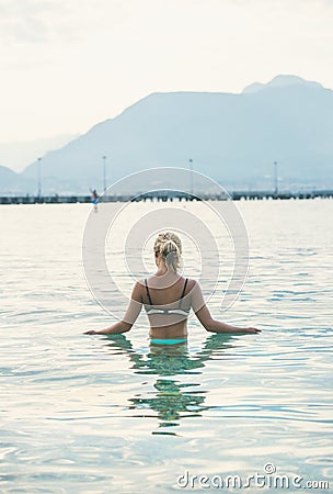 Young woman standing in still morning sea waters in Alanya Stock Photo