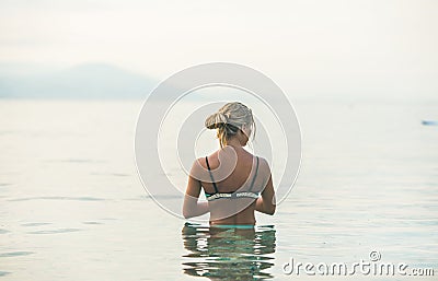 Young woman standing in still sea waters in Alanya, Turkey Stock Photo