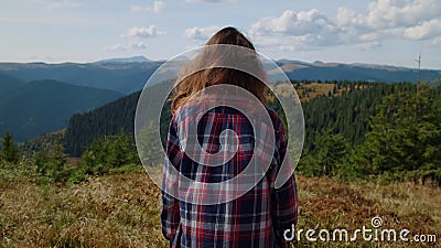 Young woman standing on top of mountain alone. Female hiker enjoying vacation Stock Photo