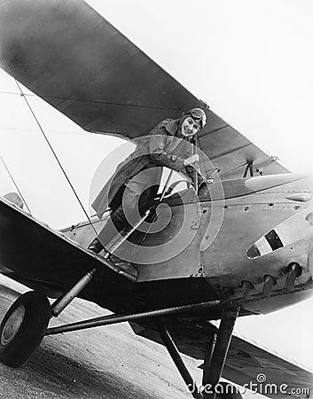 Young woman standing on the wing of an airplane Stock Photo