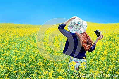 Young woman standing in yellow rapeseed field. Stock Photo