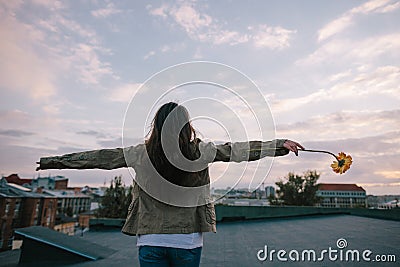 Young woman staying back with orange flower Stock Photo