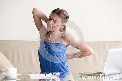 Young woman stretching suffering from sudden back pain, feeling Stock Photo