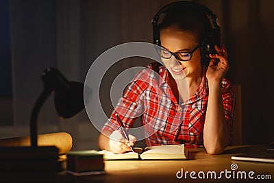 young woman student in headphones working on the computer at night Stock Photo