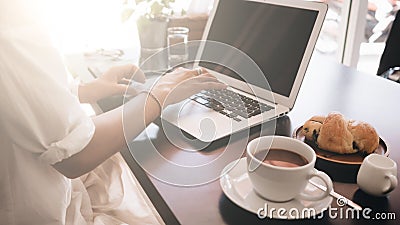 Woman working on her laptop computer sitting in cafe Stock Photo