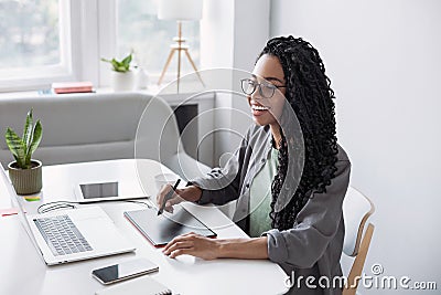 Young woman student using laptop computer at home, studying online. Creative professional working in office Stock Photo