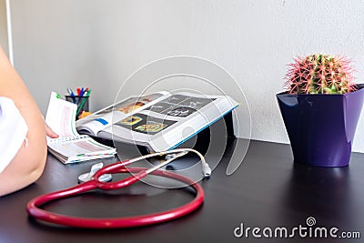 Young woman studying medicine sitting at a desk. Stock Photo