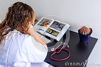 Young woman studying medicine sitting at a desk. Stock Photo