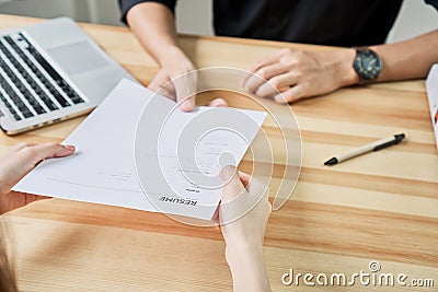 Young woman submit resume to employer to review job application. The concept presents the ability for the company to agree Stock Photo