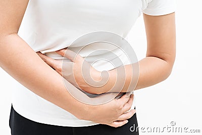 Young woman suffering from abdominal pain feeling stomachache, symptom of pms on white background Stock Photo