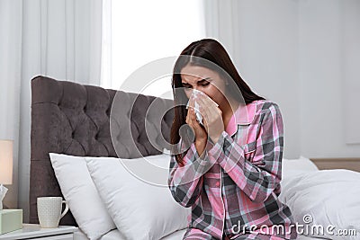 Young woman suffering from alergy in bedroom Stock Photo