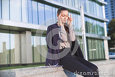 Young woman in suit settles herself down after stressful work Stock Photo