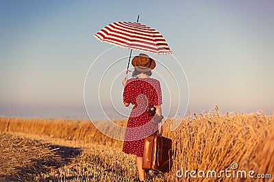 Young woman with suitcase, umbrella and camera Stock Photo